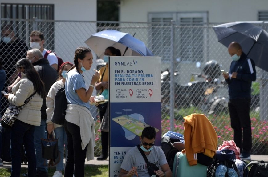 Un grupo de personas esperan turno para aplicarse una prueba contra Covid en el Aeropuerto Internacional El Dorado en Bogotá.