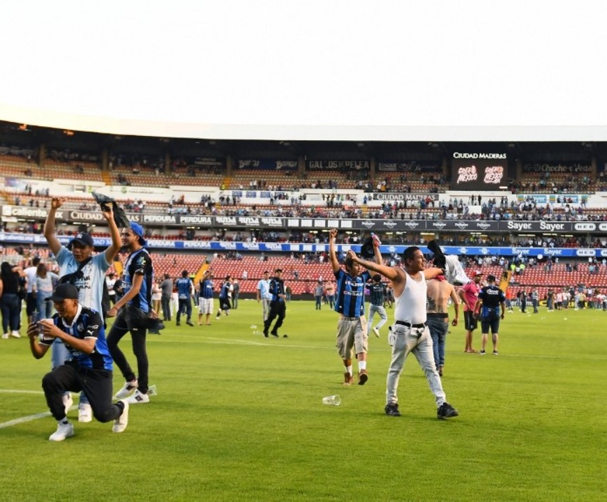 Personas en cancha de estadio de fútbol