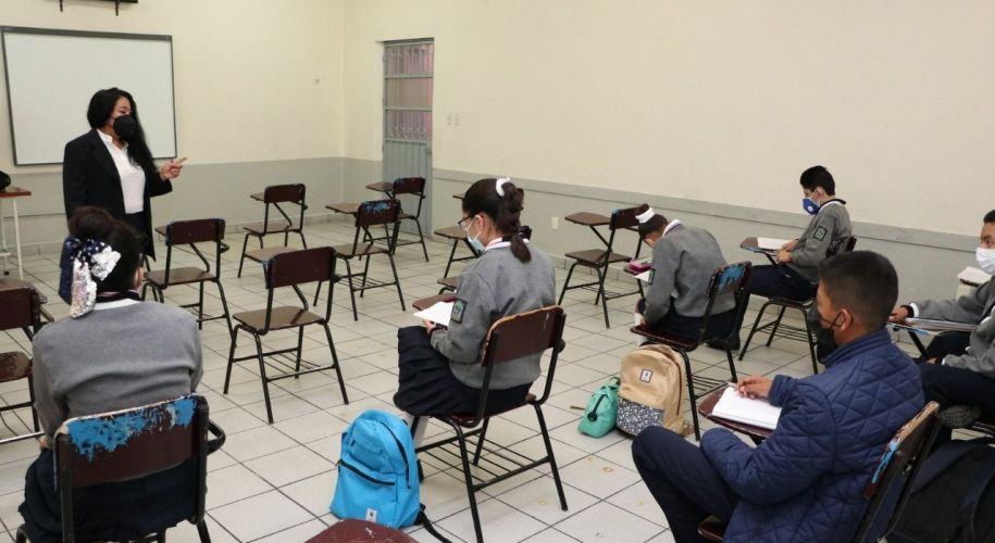 Alumnos y maestro en salón de clases
