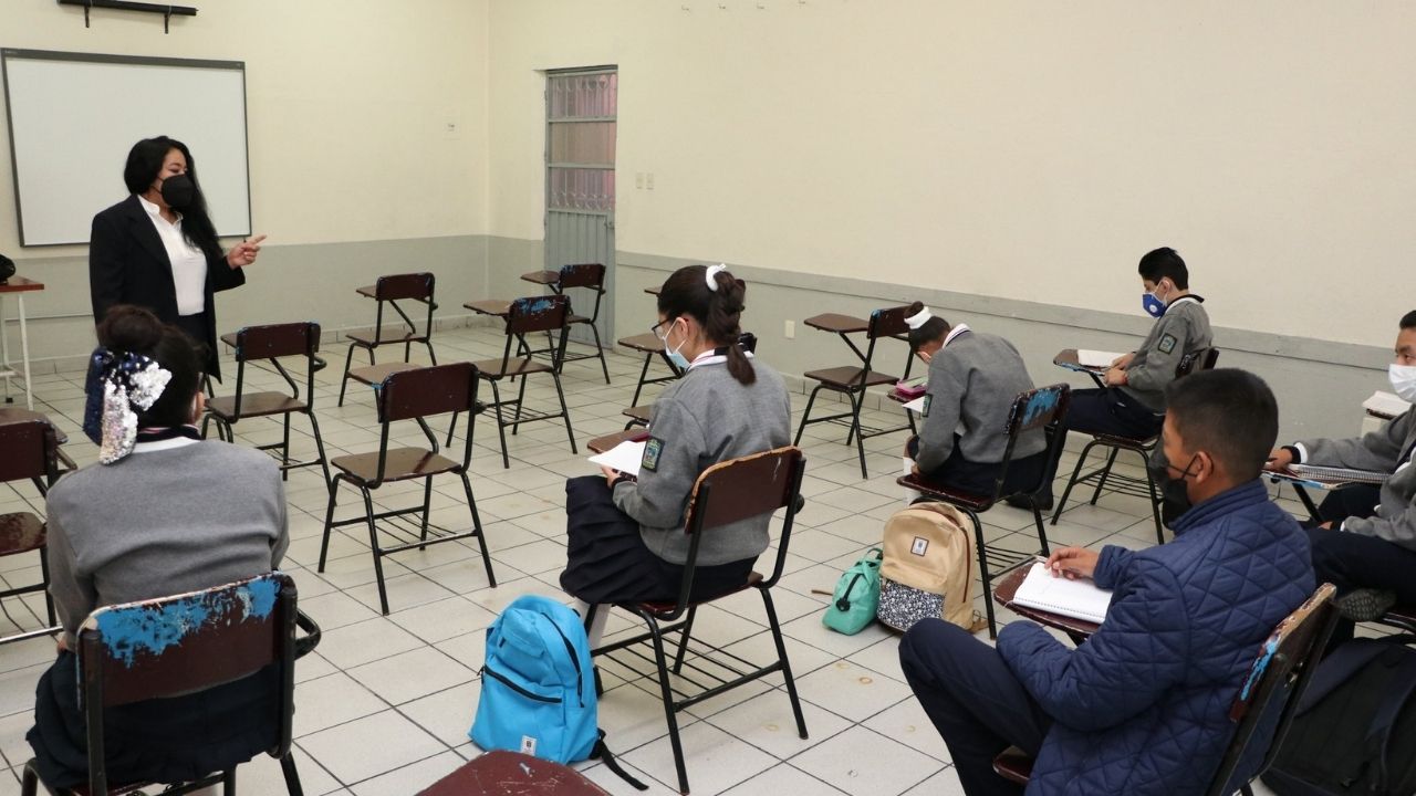 Alumnos y maestro en salón de clases