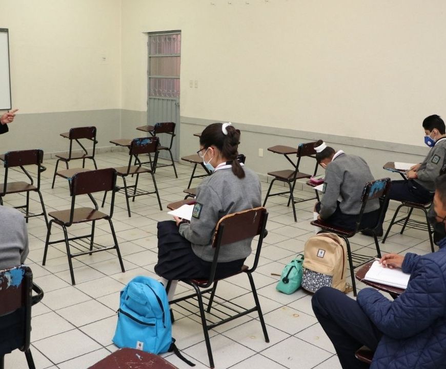 Alumnos y maestro en salón de clases