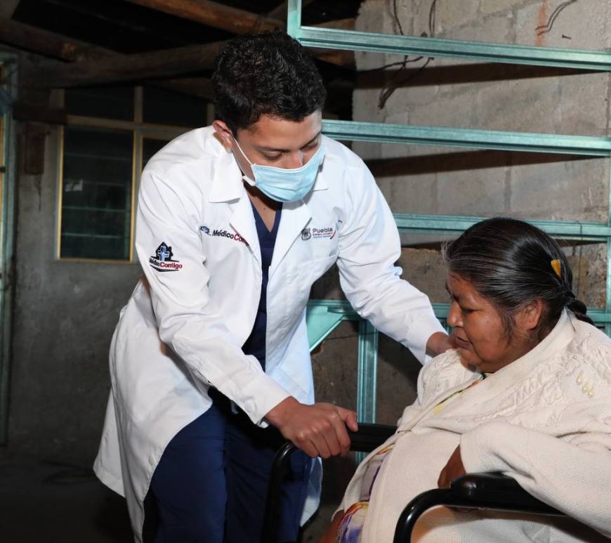 Médico atiende a mujer en silla de ruedas