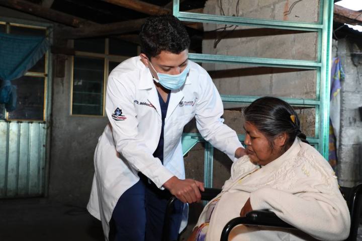 Médico atiende a mujer en silla de ruedas