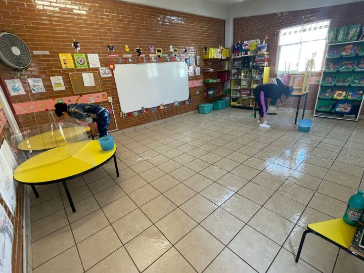 Lavan y desinfectan salón de clase