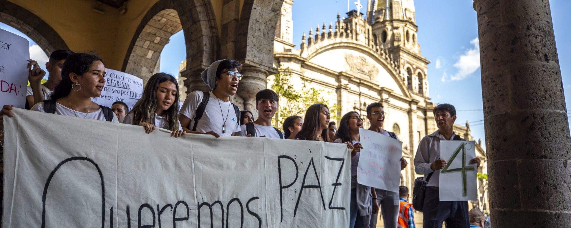 Manifestantes con pancarta de paz
