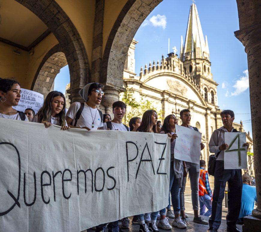 Manifestantes con pancarta de paz