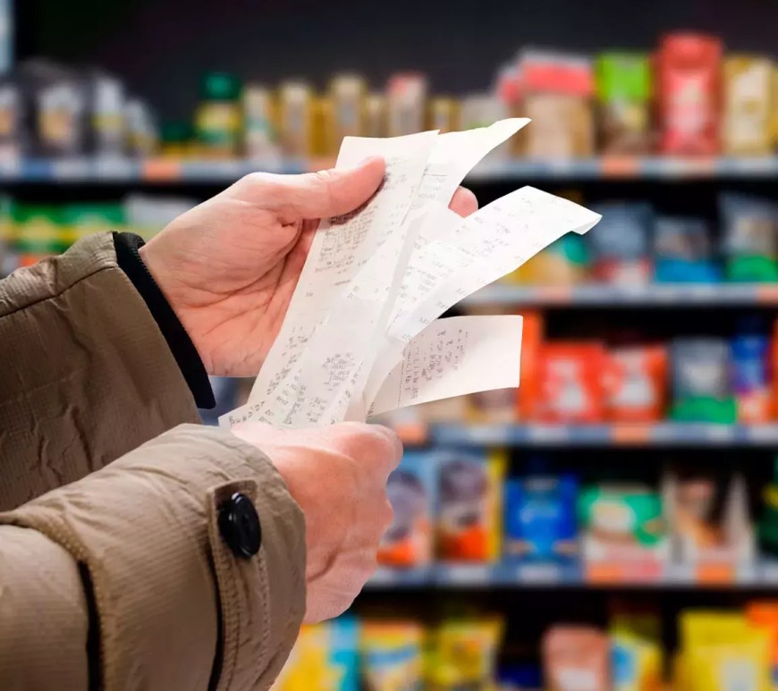 Persona mira comprobante de pago en supermercado