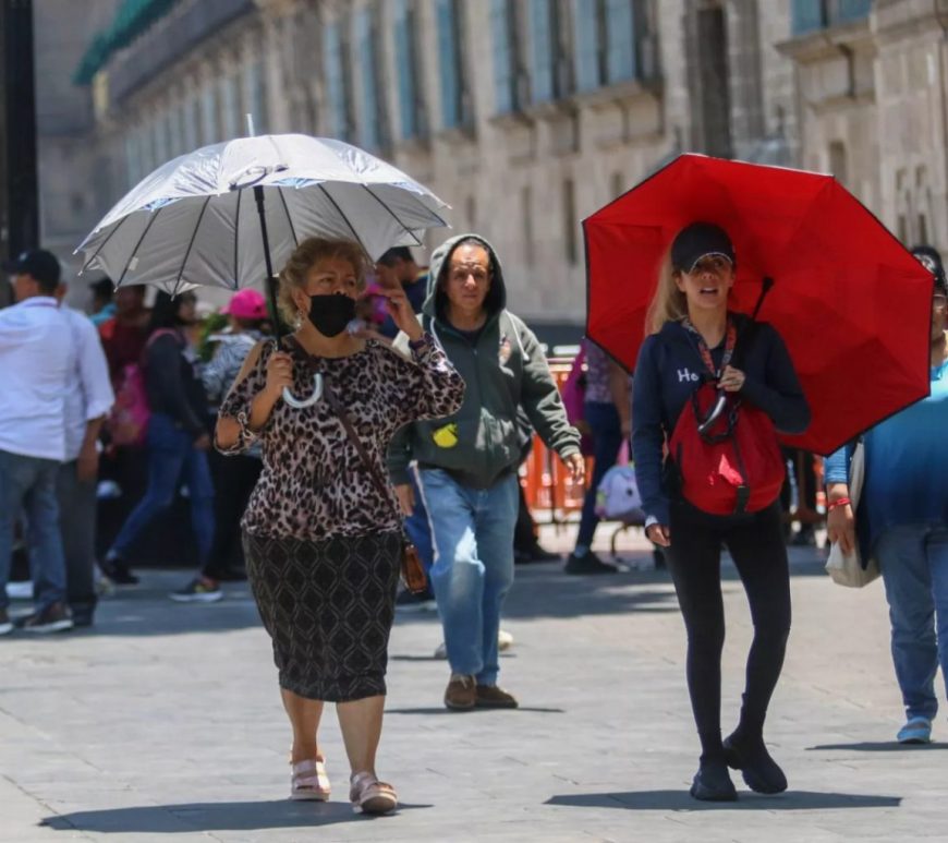 Personas con sombrilla por calor