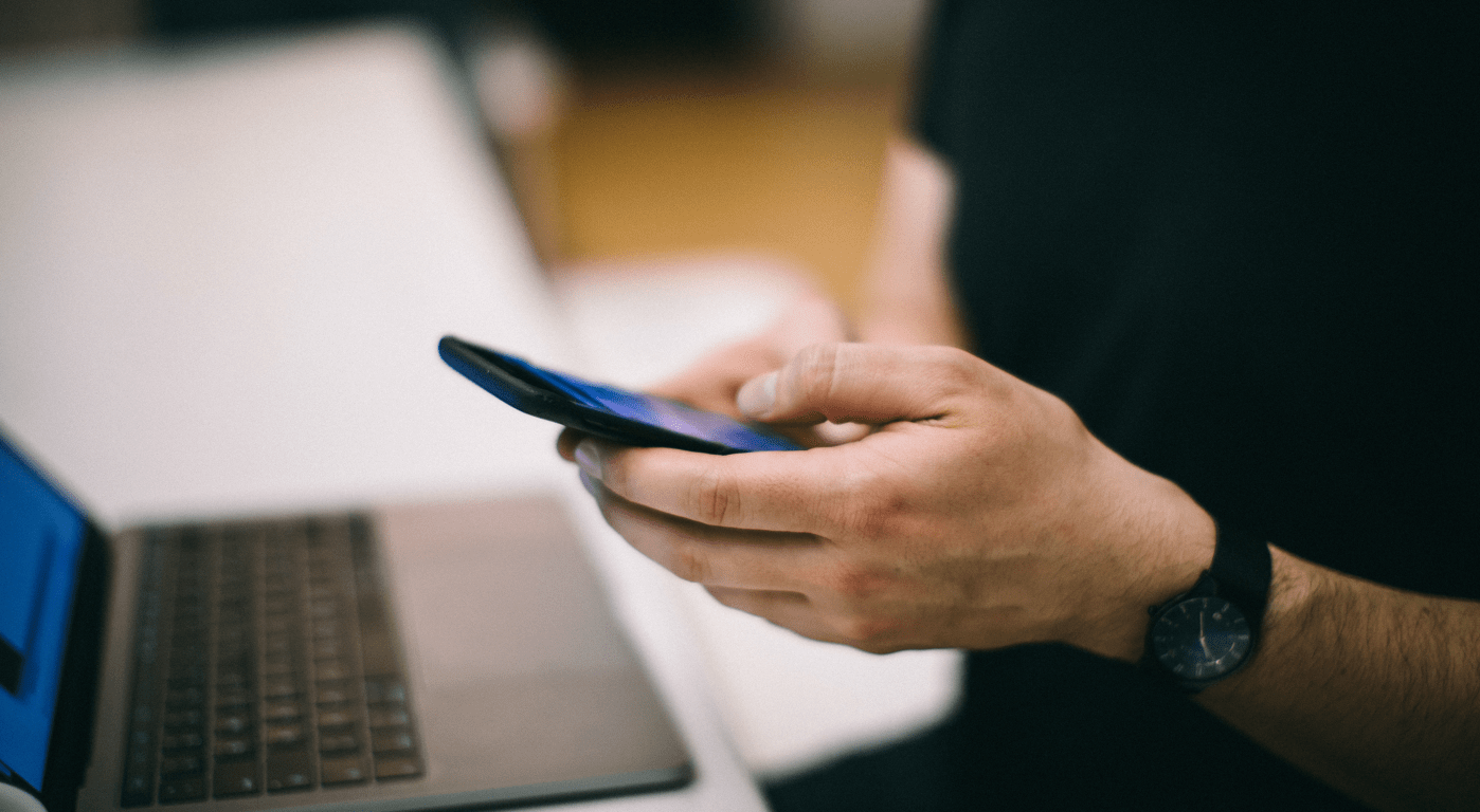 Persona con celular y computadora