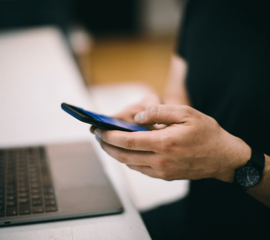 Persona con celular y computadora