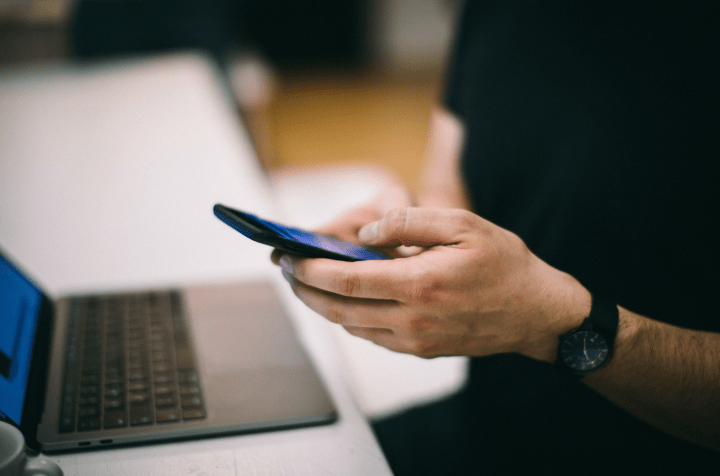 Persona con celular y computadora