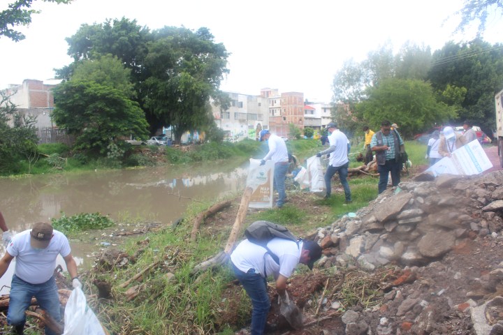 Personas limpian rio