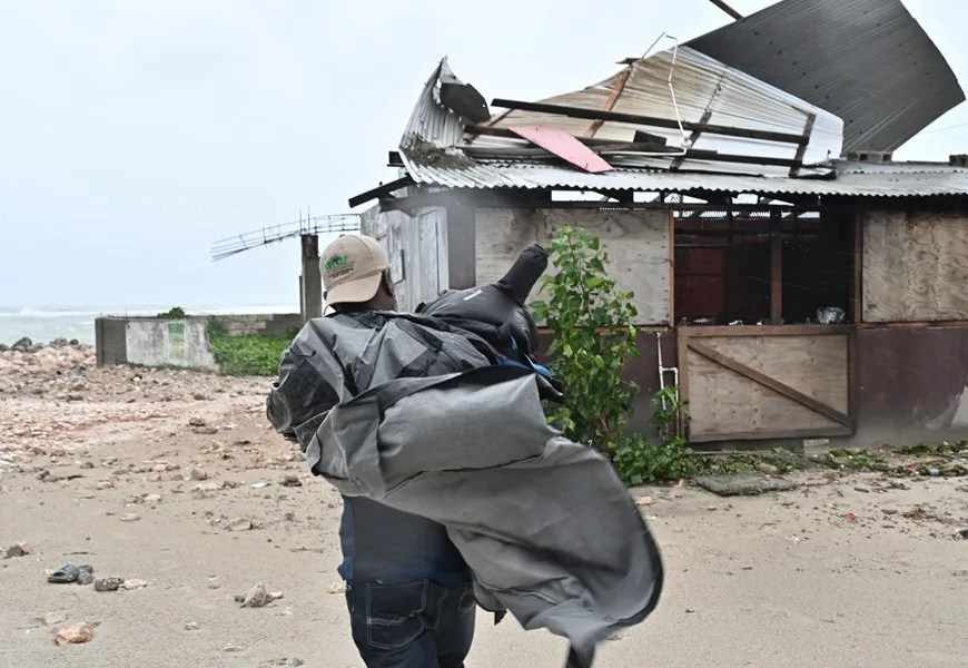 Persona de espaldas con lona en playa de Jamaica | EFE/Rudolph Brown