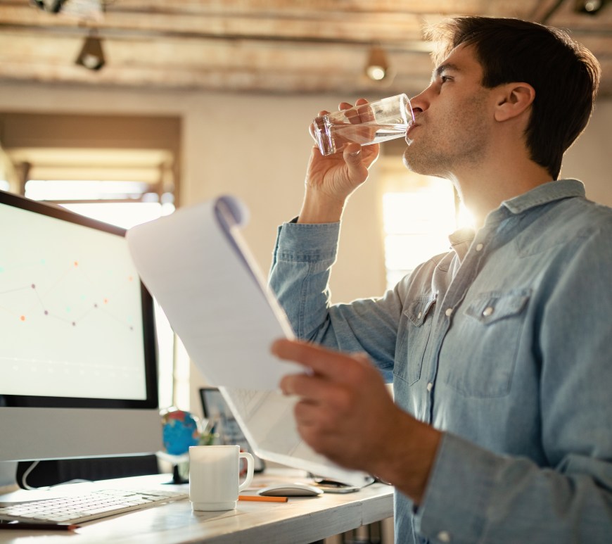 Persona bebe agua en lugar de trabajo