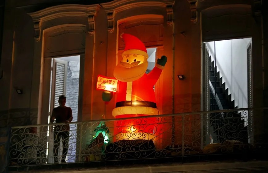 Una persona descansa en un balcón con adornos de navidad, en La Habana (Cuba) | EFE/ Ernesto Mastrascusa