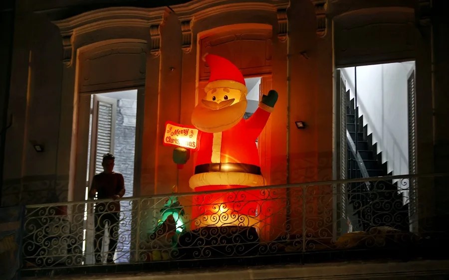 Una persona descansa en un balcón con adornos de navidad, en La Habana (Cuba) | EFE/ Ernesto Mastrascusa