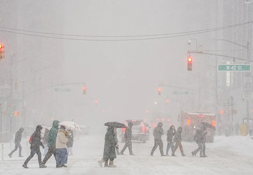 Un grupo de personas camina durante una nevada este domingo, en Manhattan (Estados Unidos). EFE/ Ángel Colmenares