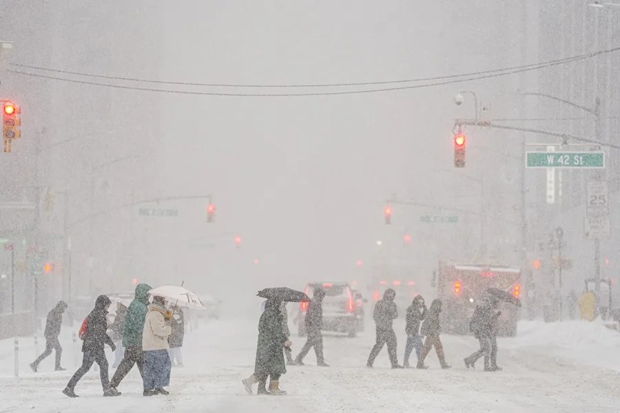 Un grupo de personas camina durante una nevada este domingo, en Manhattan (Estados Unidos). EFE/ Ángel Colmenares