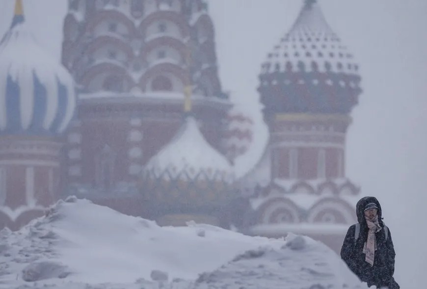 Una mujer camina por la Plaza Roja de Moscú en plena nevada. | EFE/EPA/Sergei Ilnitsky