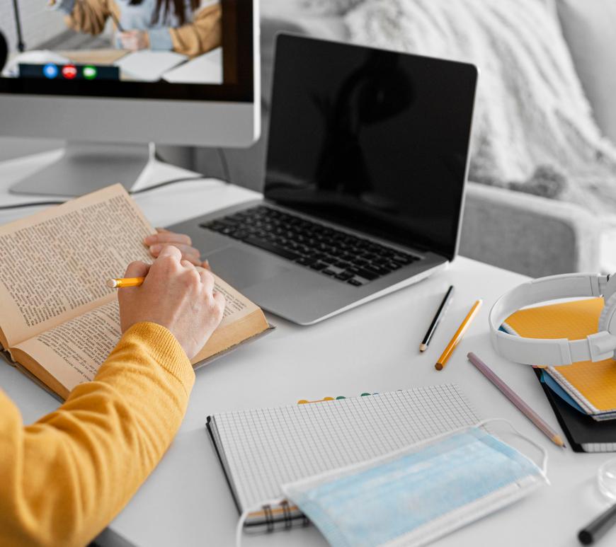 Persona con libreta, libro y computadora