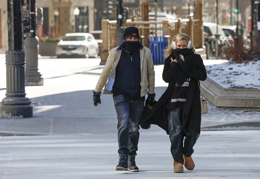 Una pareja se protege del frío mientras camina, este 23 de enero de 2026, en Chicago, ante la tormenta invernal que enfrenta Estados Unidos. EFE/Kamil Krzacztnski