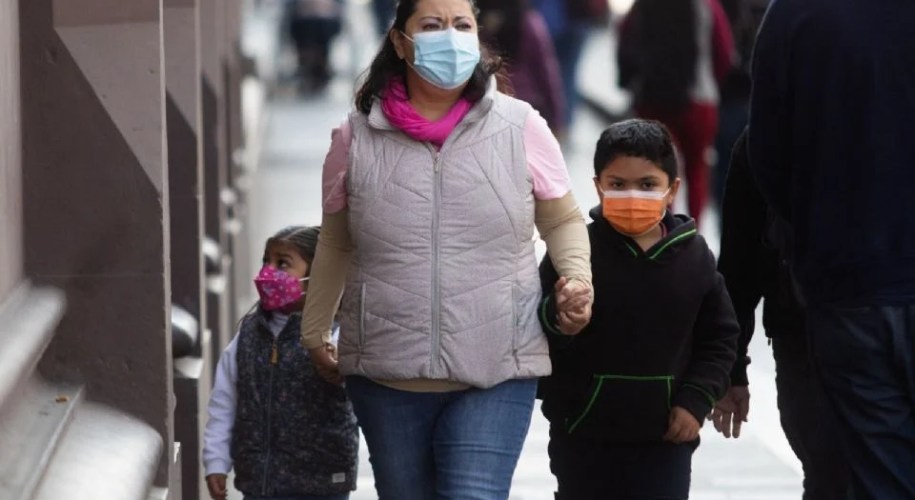 Madre con alumnos con cubrebocas
