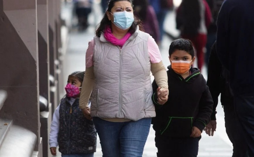 Madre con alumnos con cubrebocas