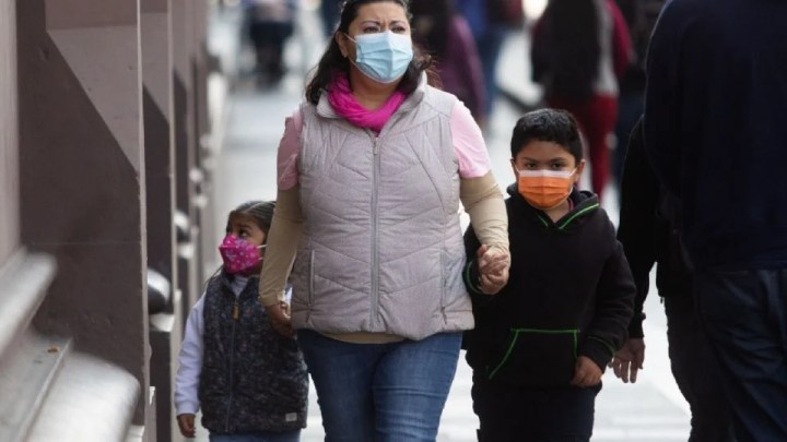 Madre con alumnos con cubrebocas