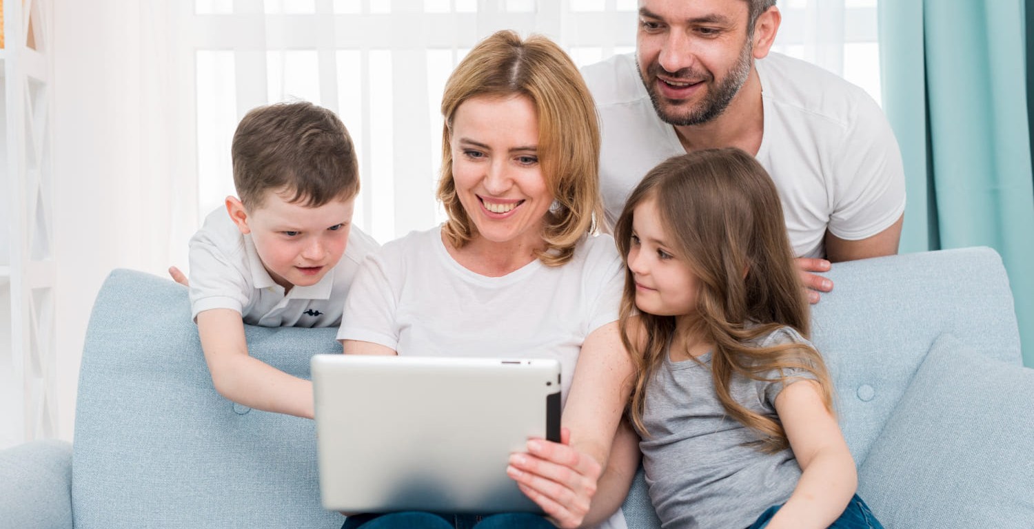 Familia en sala frente a computadora