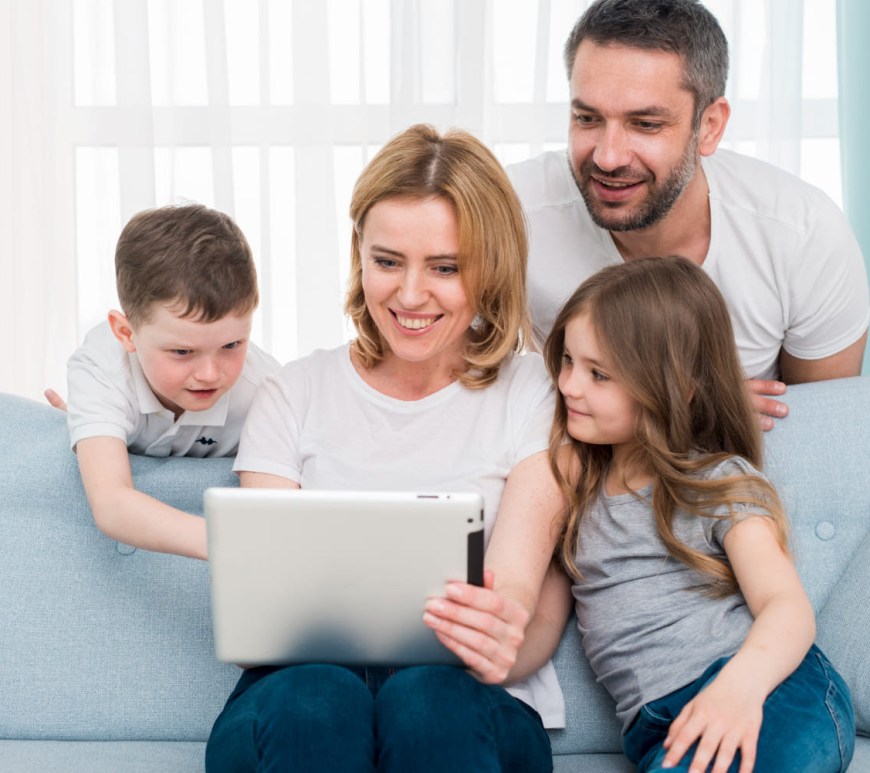 Familia en sala frente a computadora
