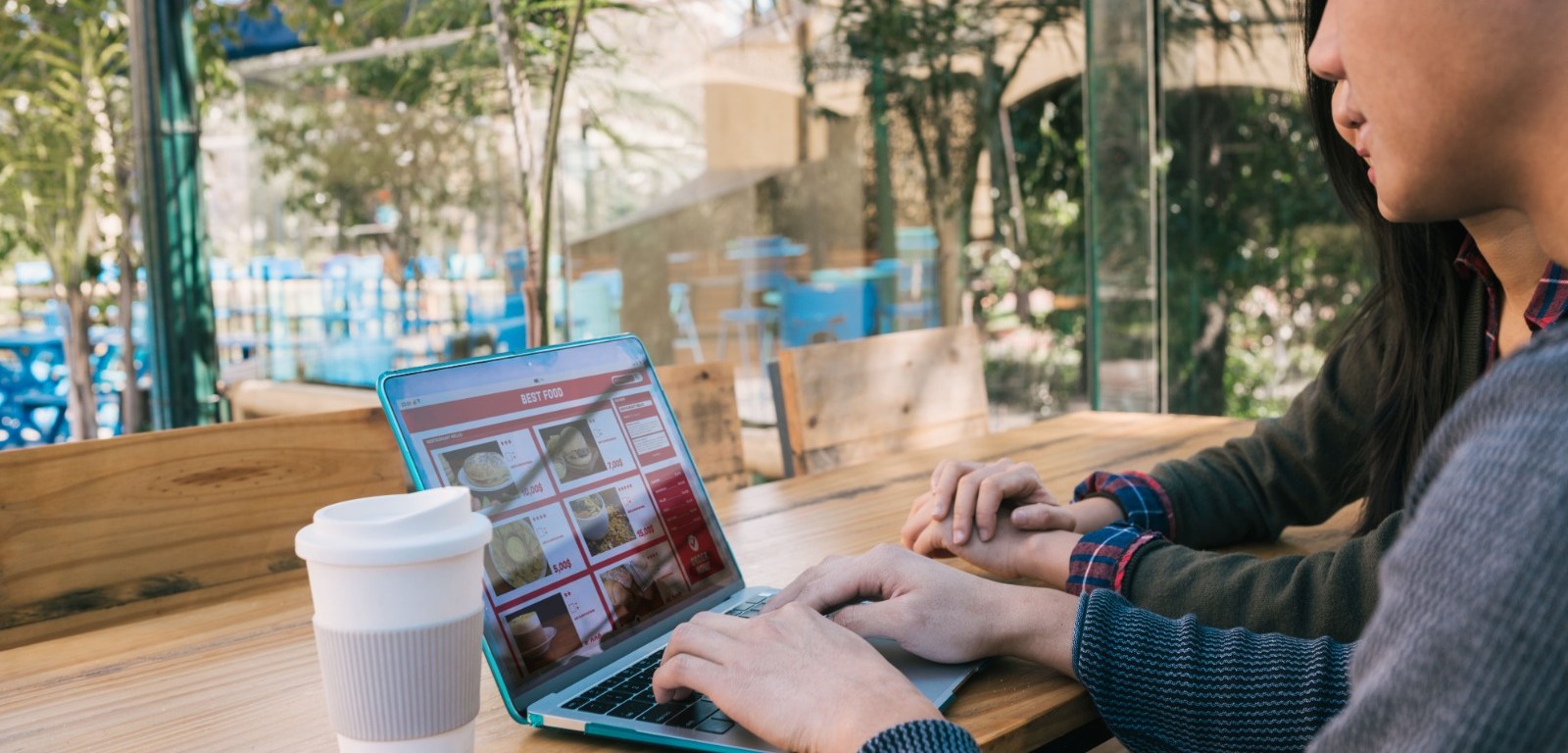 Joven en patio y trabaja en computadora