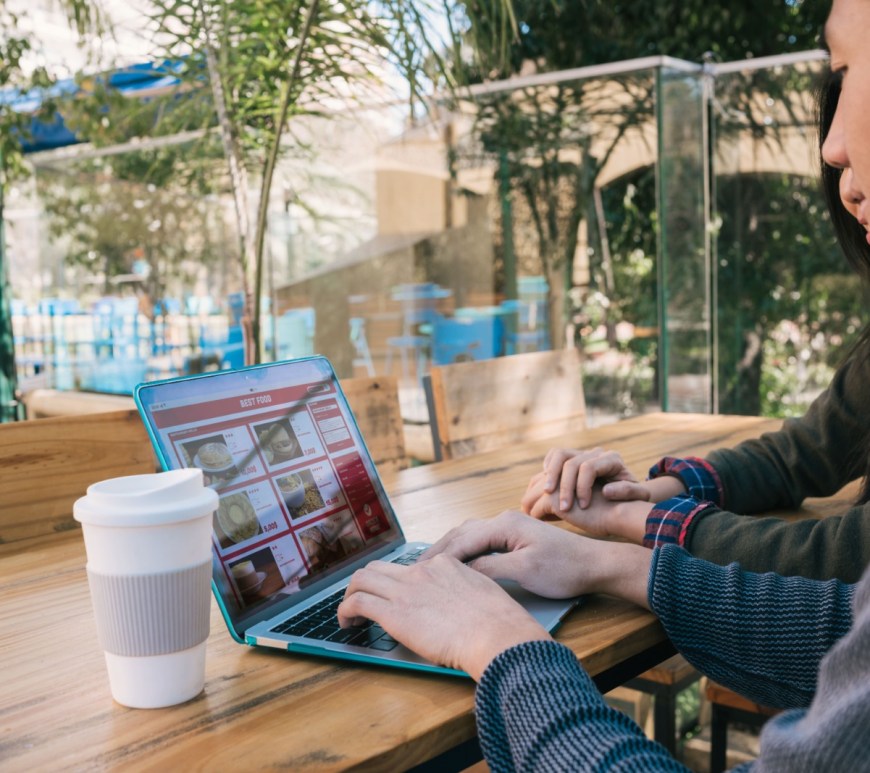 Joven en patio y trabaja en computadora