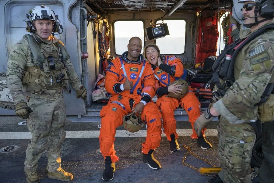 Imagen facilitada por la NASA los astronautas Victor Glover (i) Christina Koch, sentados en un helicóptero MH-60 Seahawk de la Armada. EFE/EPA/Bill Ingalls/ NASA