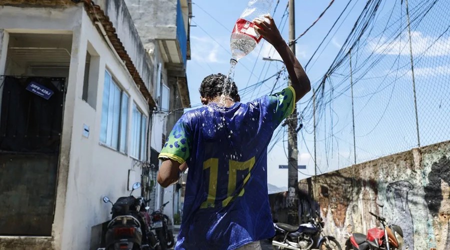 Un joven se baña en las calles de la favela de Tavares Bastos en Río de Janeiro (Brasil). EFE/ Antonio Lacerda/ Archivo