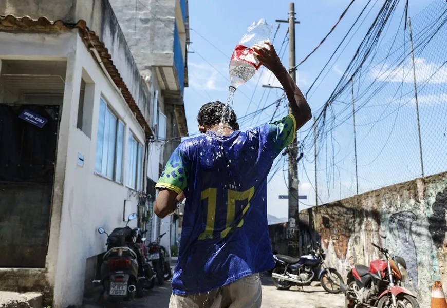 Un joven se baña en las calles de la favela de Tavares Bastos en Río de Janeiro (Brasil). EFE/ Antonio Lacerda/ Archivo