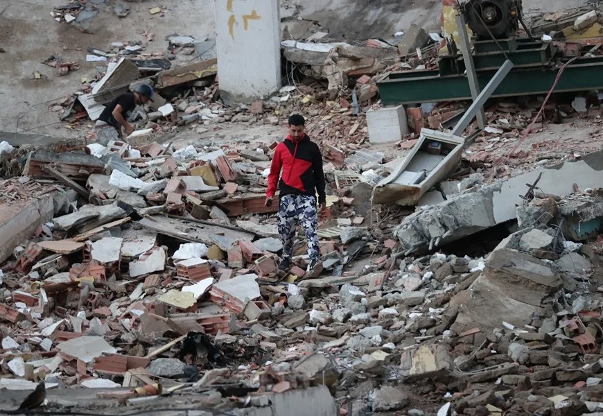 Un residente camina entre los escombros de edificios derrumbados por los terremotos, en la localidad de Catia La Mar, en el estado costero de La Guaira (Venezuela), este jueves. EFE/ Ronald Pena R.
