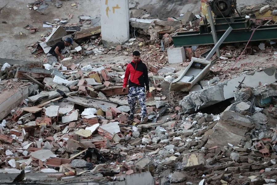 Un residente camina entre los escombros de edificios derrumbados por los terremotos, en la localidad de Catia La Mar, en el estado costero de La Guaira (Venezuela), este jueves. EFE/ Ronald Pena R.