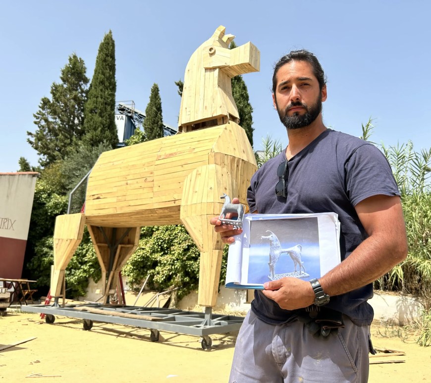Ramón Rico, creador del diseño original del Caballo de Troya que se construye en Gilena (Sevilla) posa con la maqueta inicial ante el proyecto que se ha logrado, de seis metros de altura. EFE/Fermín Cabanillas