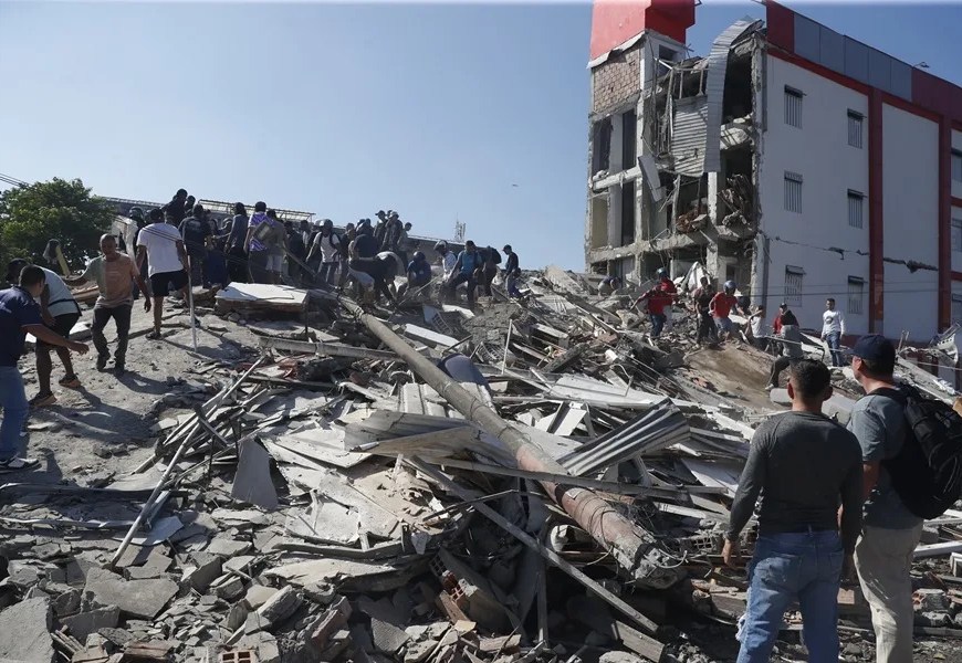 Personas caminan sobre los escombros de un edificio colapsado este lunes, en Cali (Colombia). EFE/ Ernesto Guzmán