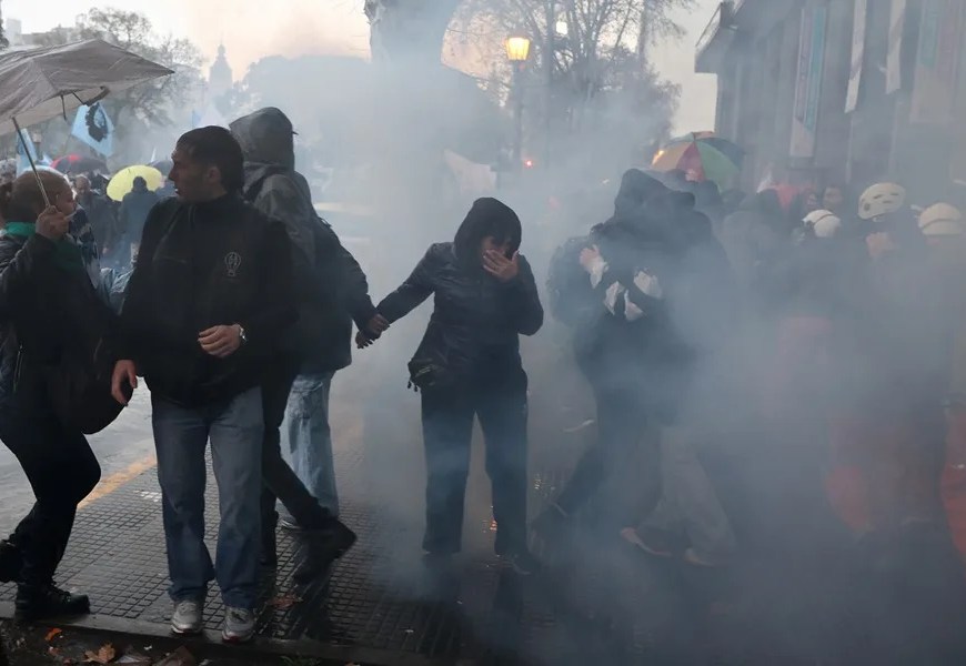 Personan son afectadas por el gas lacrimógeno durante una manifestación contra un proyecto de ley impulsado por el Gobierno del ultraliberal Javier Milei que introduce cambios en los procesos de desalojo, expropiaciones y uso de tierras quemadas, este jueves en Buenos Aires (Argentina). EFE/ Juan Ignacio Roncoroni