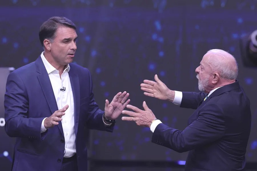 El presidente de Brasil y candidato a la reelección, Luiz Inácio Lula da Silva (d), y el opositor Flávio Bolsonaro, discuten durante el primer debate presidencial este domingo, en la sede de Rede Bandeirantes en Sao Paulo (Brasil). EFE/ Sebastiao Moreira