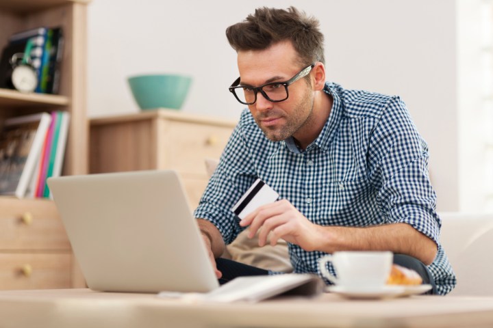 Persona con tarjeta de credito en computadora